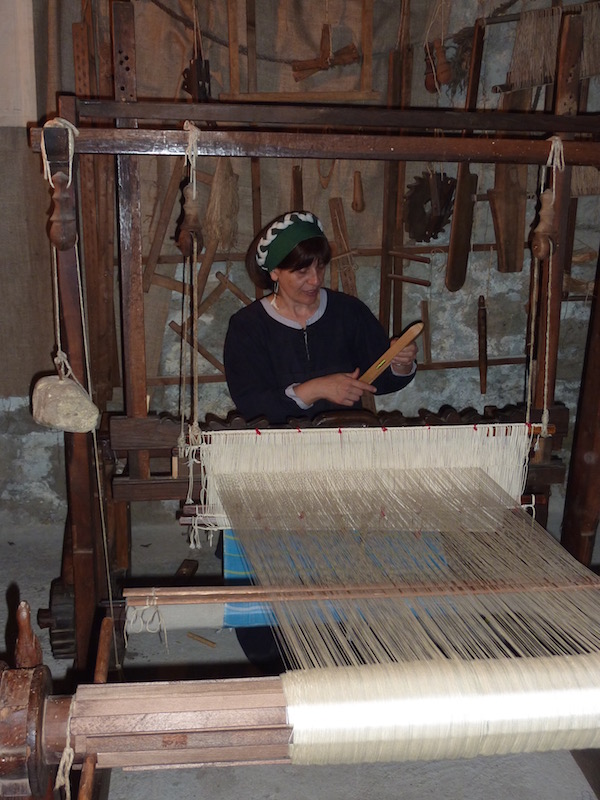 A weaver working on an antique loom
